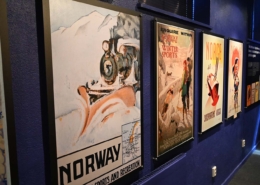 Bilde av reiselivsplakater på en vegg.