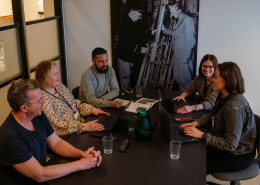 fem personer i møte på kontor