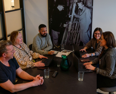 fem personer i møte på kontor